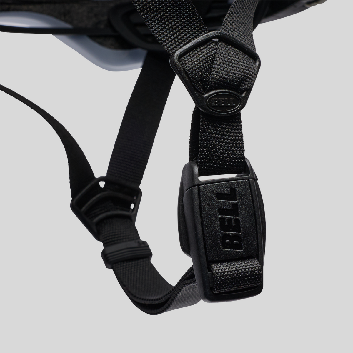 Detalle de la hebilla magnética Fidlock y correas ajustables del casco MZ Bikes Bell XR Spherical en color blanco